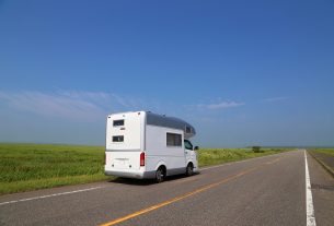 どこまでも続く一本道を走るキャンピングカー