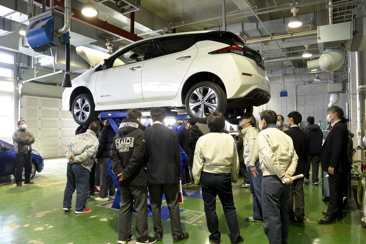 日産・リーフの車体下部構造について講師の説明を聞く高等学校の生徒たち